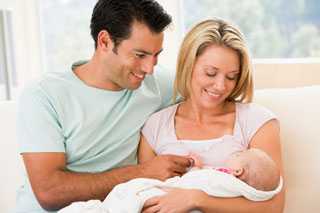 Couple in living room with baby.