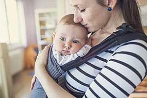 Smiling mother hugging baby