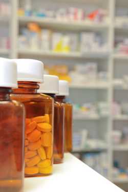 rows of bottles and pills in a pharmacy