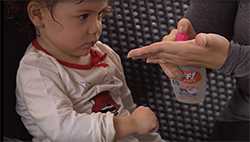 Mother applying insect repellant on a little girl